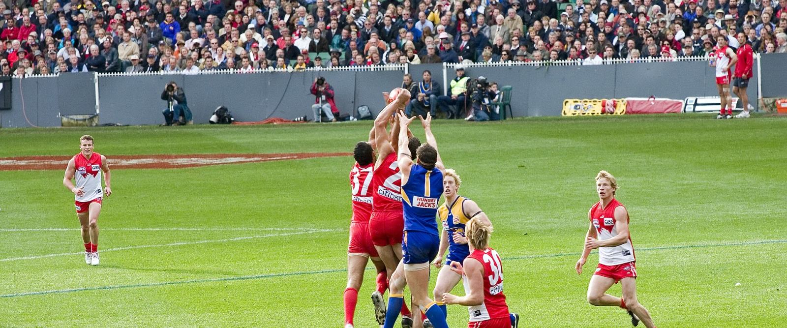 Australian rules footballers contesting a mark in front of goal