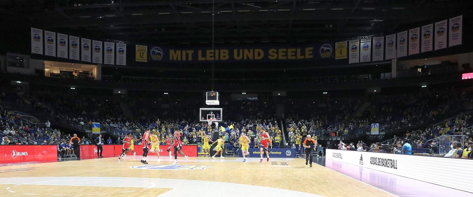 A EuroLeague basketball game seen wide across a floodlit arena court