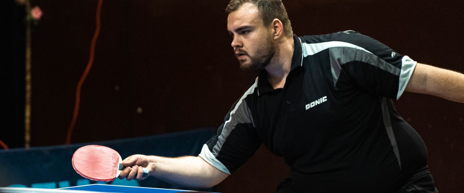 A table tennis player striking a forehand during a match