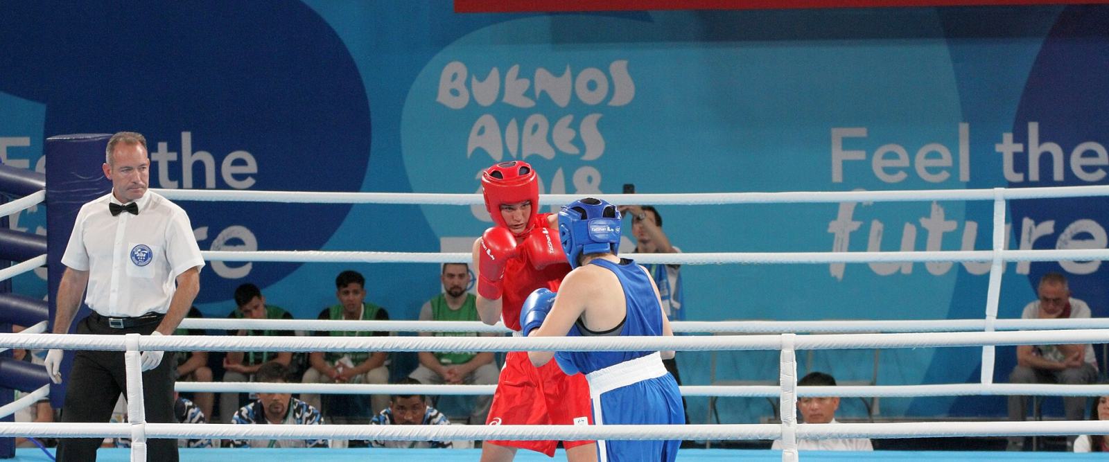 Two boxers exchanging punches in the ring as the referee watches